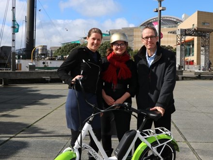 Three people standing with E-bike