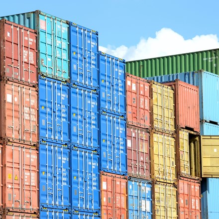 Colourful shipping containers stacked (red, blue, yellow, brown, green) 