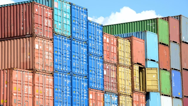 Colourful shipping containers stacked (red, blue, yellow, brown, green) 