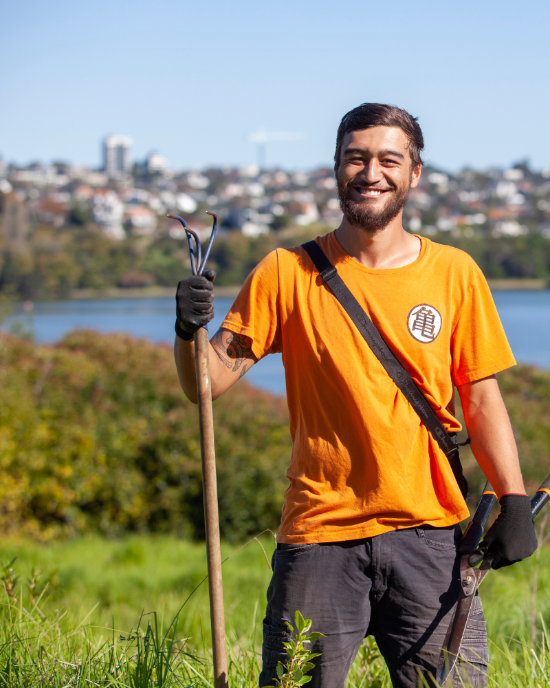 Man holding planting tool in front waterway