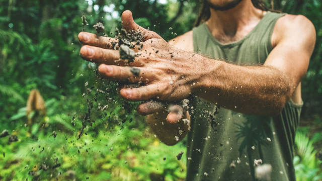 Man brushing dirt out of hands