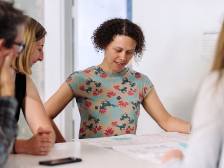 Individual working with others at planning table