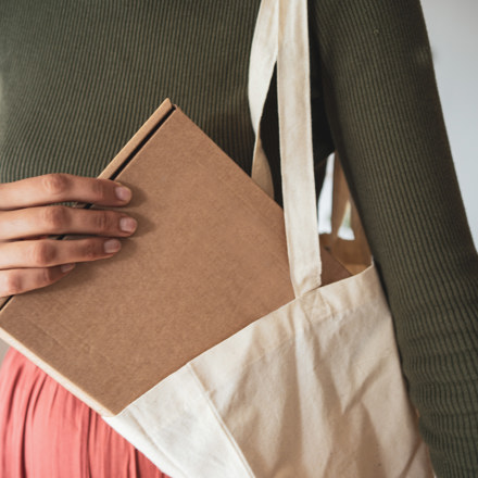 Lady pulling brown box out of bag