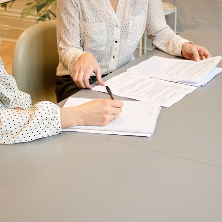 Two ladies signing contracts