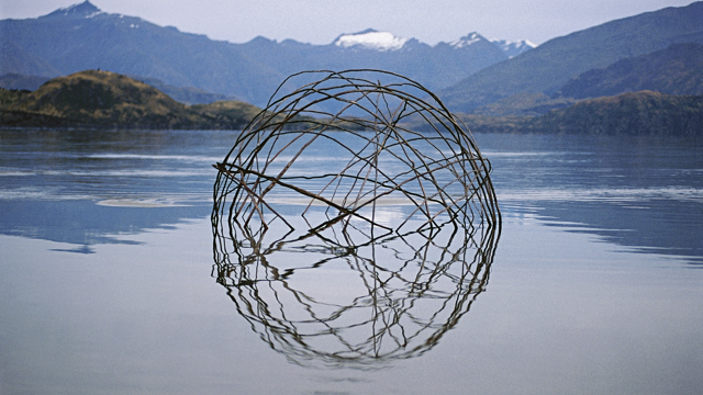 Spherical structure in lake with mountain backdrop