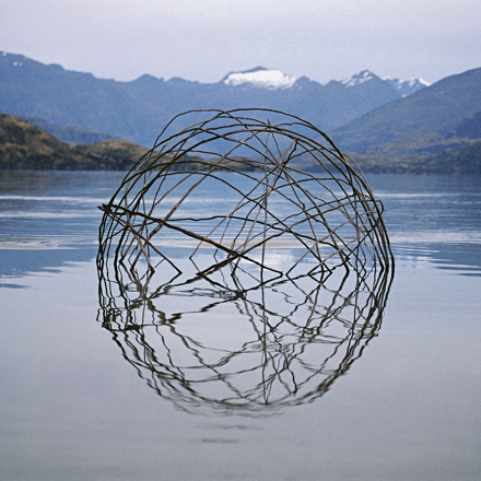 Spherical structure in lake with mountain backdrop