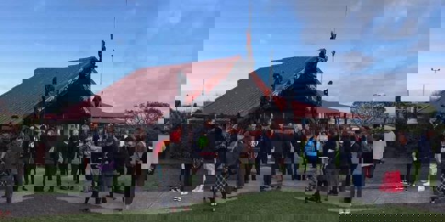 People gathering outside a marae