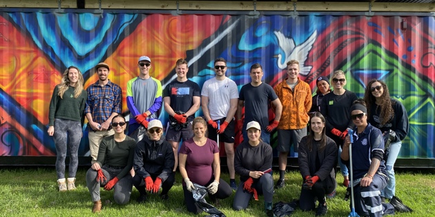 Vounteers in front of a colourful mural at the Puhinui Regeneration Project