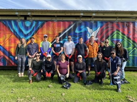 Vounteers in front of a colourful mural at the Puhinui Regeneration Project