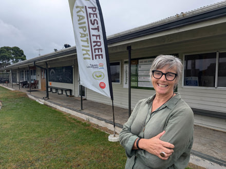 Mary Dignan in front of Pest Free Kaipātiki building