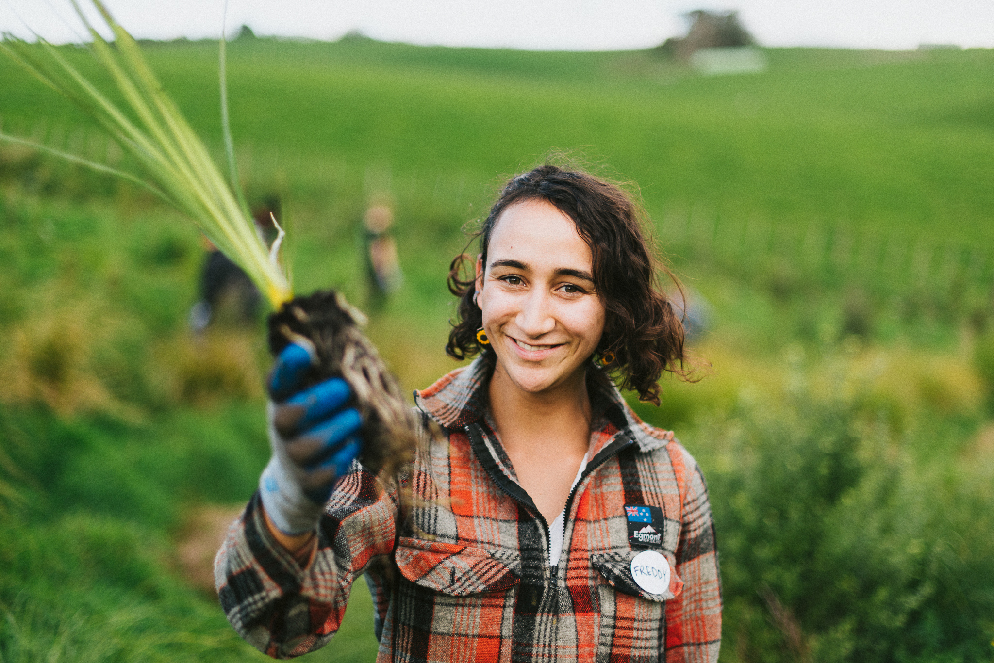 Woman holding native seedling up to the camera