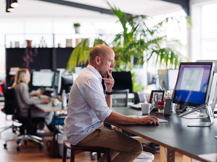 Man working at computer on long desk