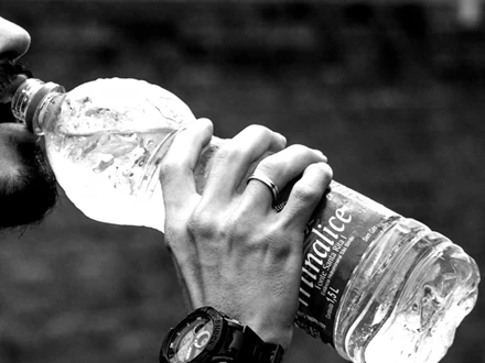 Man drinking from plastic bottle
