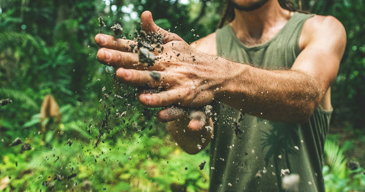 Close up of man breaking up dirt between his hands