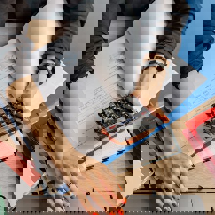 Desk with laptop, calculator and papers