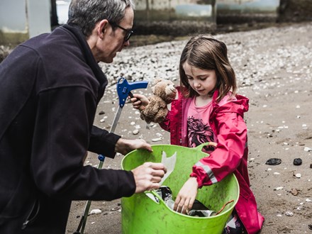 Father and daughter collecting rubbish on the beach
