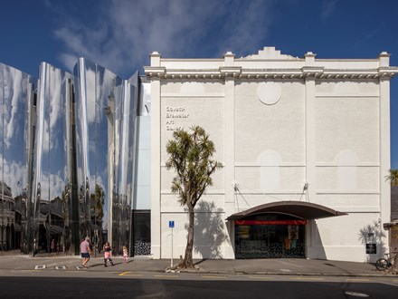 Image of a large art gallery with a cabbage tree in front 