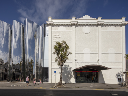 Image of a large art gallery with a cabbage tree in front 