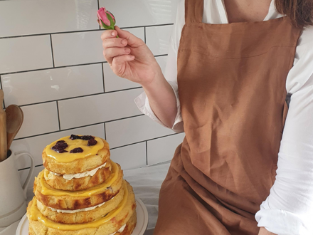 Lady holding fresh flower over beautifully decorated cake
