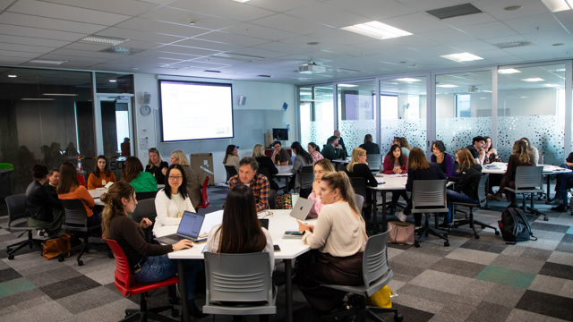 Small groups in discussion seated around tables