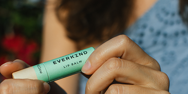 Woman holding lip balm tube 