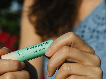 Woman holding lip balm tube 