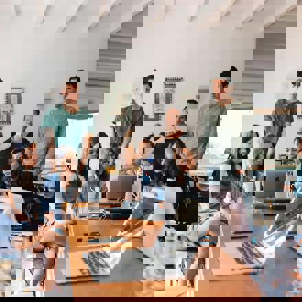 Team gathers around laptop