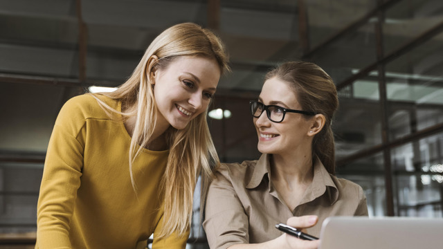 Two woman at desk with laptop
