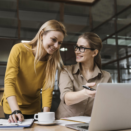 Two woman at desk with laptop