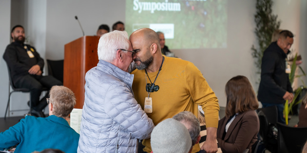 Two men greeting with hongi at a business event