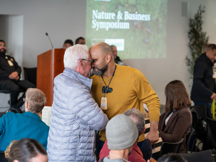 Two men greeting with hongi at a business event