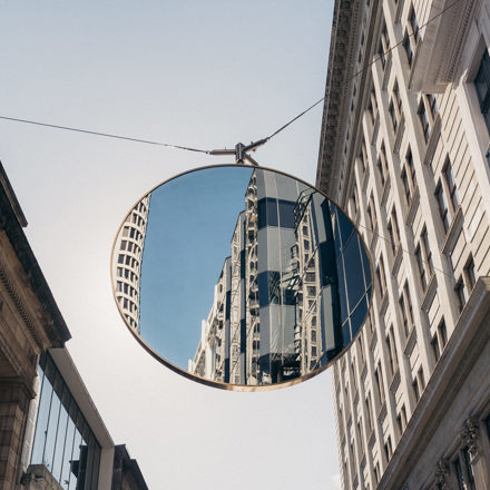Buildings reflected in round mirror