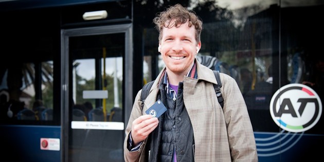 Commuter with AT HOP card in front of bus
