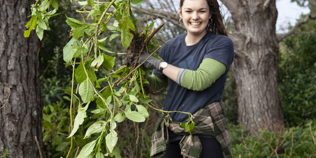 Woman holding up weeds after maintenance day 