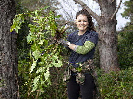 Woman holding up weeds after maintenance day 