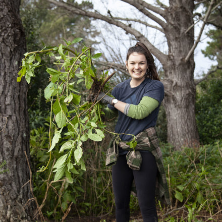 Woman holding up weeds after maintenance day 